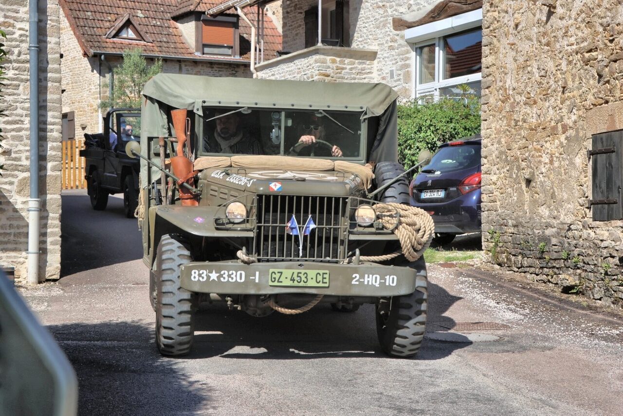 Convoi de jeeps traversant un village